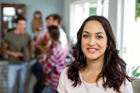 Portrait of happy woman with friends enjoying at homeの写真素材