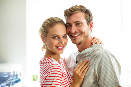 Portrait of smiling young couple in kitchen at homeの写真素材