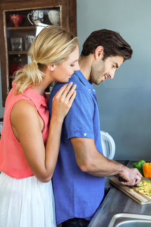 Young couple chopping vegetables in kitchen at homeの写真素材