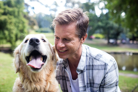 Smiling man with his pet dog in the park