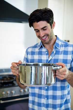 Young man preparing food in kitchen at homeの写真素材