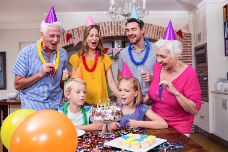 Multi-generation family in party hats having fun at birthday partyの写真素材