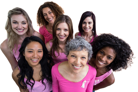 Smiling women in pink outfits posing for breast cancer awareness on white backgroundの写真素材