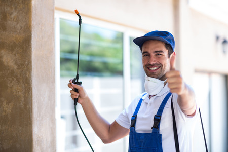 Portrait of confident pesticide worker with thumbs up sign in back yardの写真素材