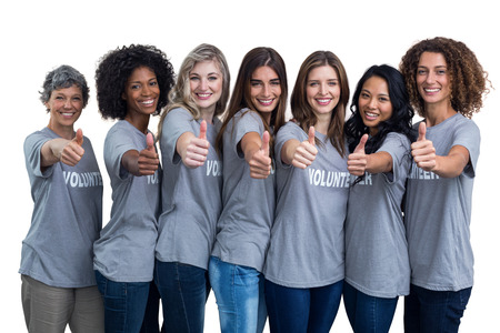 Portrait of happy volunteers showing their thumbs up on white backgroundの写真素材