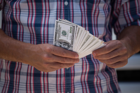 Close-up of man counting currency noteの写真素材