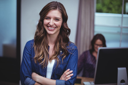 Portrait of beautiful woman standing with arms crossed at homeの写真素材