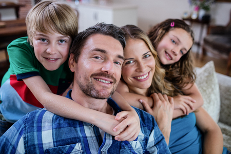 Portrait of happy family sitting on a sofa at home