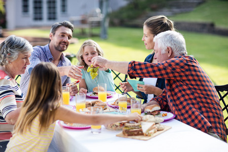 Happy family having lunch in the garden on a sunny dayの写真素材