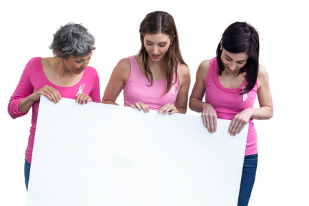 Women in pink outfits holding board for breast cancer awareness on white backgroundの写真素材
