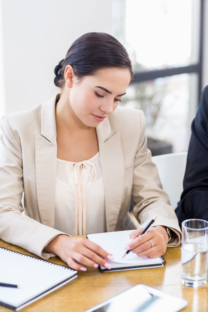 A businesswoman is concentrating and looking at her notes on officeの写真素材