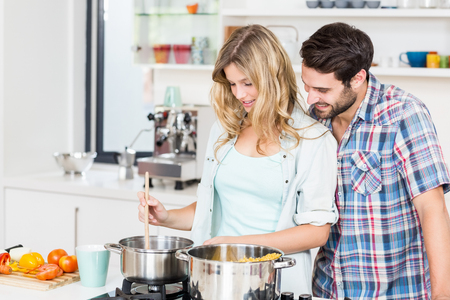 Smiling young couple cooking food in the kitchenの写真素材