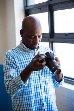 Man checking photo in camera in officeの写真素材