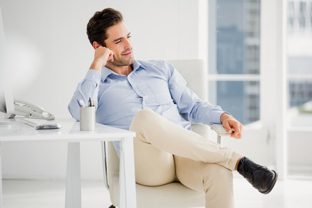 Businessman sitting at his desk in the officeの写真素材