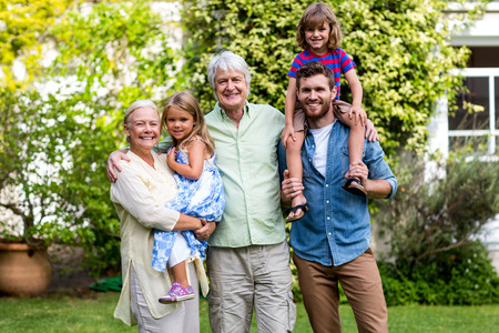 Portrait of grandparents with grandchildren and son at yard