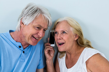 Happy retired couple listening to music through smartphoneの写真素材