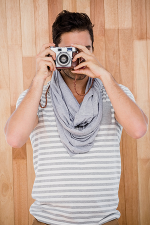Handsome man taking a photograph with digital cameraの写真素材