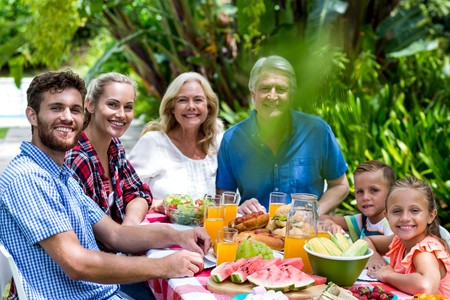 Portrait of happy family having lunch in yard