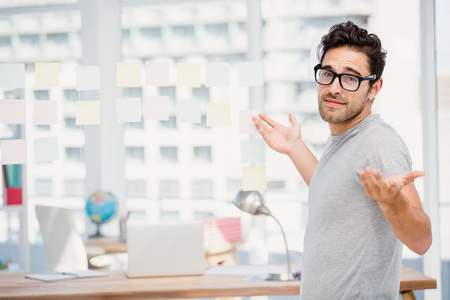 Man shrugging his shoulder in office to say I do not knowの写真素材