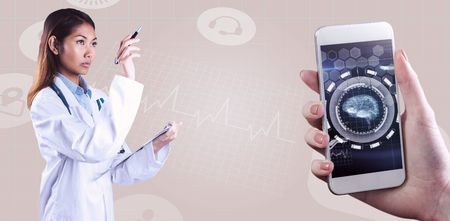 Asian doctor pointing with pen against medical interface in blue and blackの写真素材