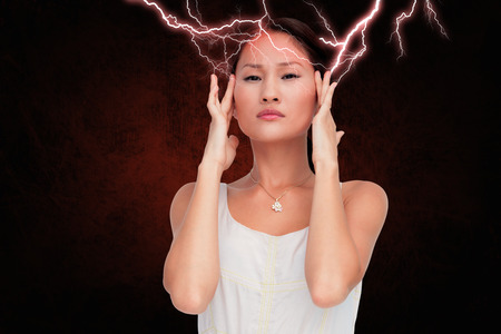 Concerned woman posing and looking at camera against dark backgroundの写真素材