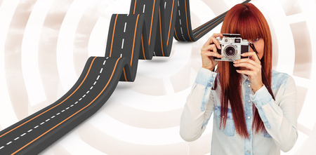 Attractive hipster photographing with camera against beige background