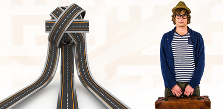 Serious hipster holding a suitcase against orange backgroundの写真素材