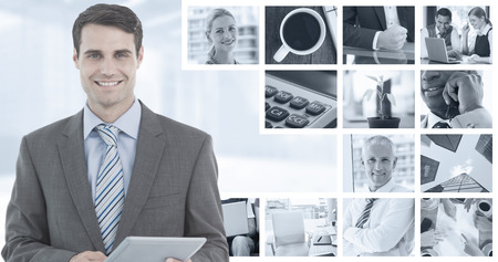 Businessman using a tablet  with colleagues behind in office against composite image of plant on desk in the officeの写真素材