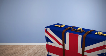 Great Britain flag suitcase against room with wooden floor