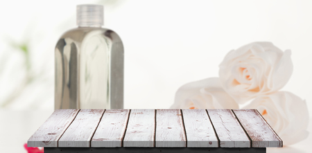 Wooden floor against glass flask with petals and rosesの写真素材
