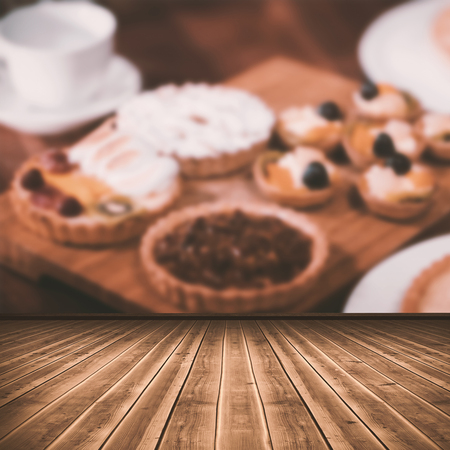 High angle view of gray hardwood floor against close up wooden tray of tasty pastries