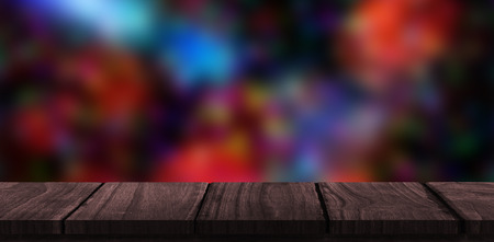 Wooden desk against colourful glowing dots on black
