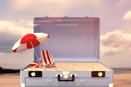 Image of a suitcase against beach with blue skyの写真素材