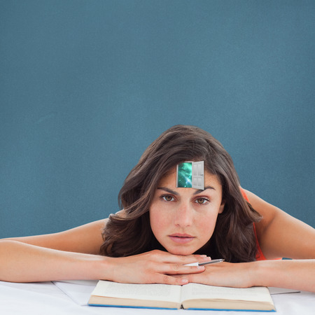 Frowning student head on her books against blue backgroundの写真素材