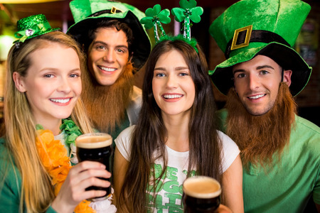 Smiling friends with Irish accessory in the barの写真素材