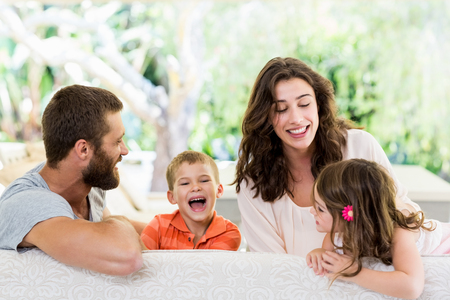Happy parents having fun with their kids fun in living roomの写真素材