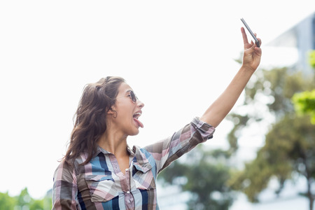 Young woman taking selfie on a mobile phoneの写真素材