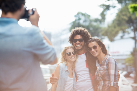 Man taking photo of his friends outdoorsの写真素材