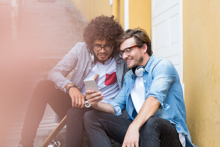 Friends sitting on staircase using mobile phone