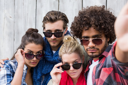 Group of friends in sunglasses posing for selfieの写真素材