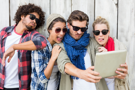 Group of friends taking selfie on digital tabletの写真素材