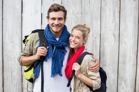 Portrait of happy young couple carrying backpackの写真素材