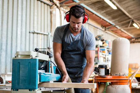 Carpenter working on his craft in a dusty workshop