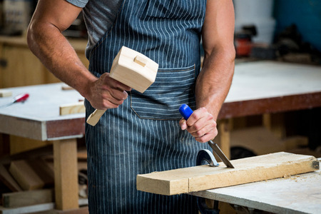 Carpenter working on his craft in a dusty workshop