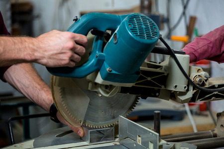 Carpenter working on his craft in a dusty workshopの写真素材