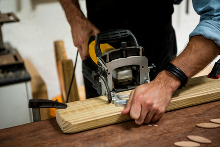 Carpenter is posing with his craft in a dusty workshopの写真素材