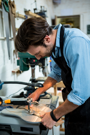 Carpenter working on his craft in a dusty workshopの写真素材