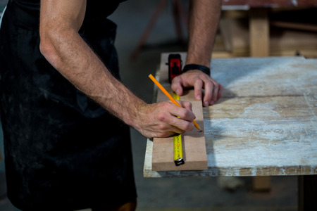 Carpenter working on his craft in a dusty workshopの写真素材