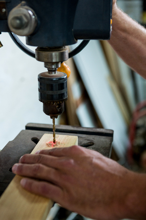 Carpenter using a drill in his workshopの写真素材