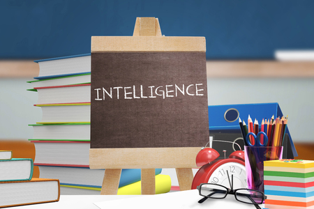 Intelligence word against red apple on pile of books in classroomの写真素材